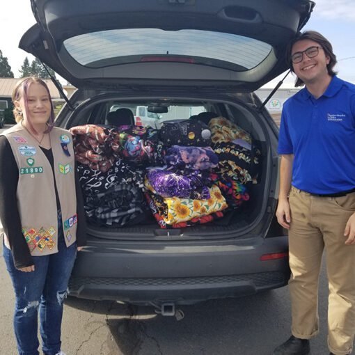 Girl Scout Mackenzie Grimes and Jake Bentz, the SIT distribution coordinator at Anthony Hall in Sublimity, with Mackenzie’s hand-made and donated blankets.