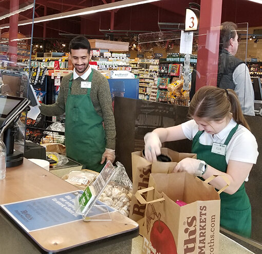 Jacob Rider and Ellie Bright help customers at Silverton’s Roth’s Fresh Market. Recently installed Plexiglas shields compensate for the 6-foot distancing guideline. Brenna Wiegand