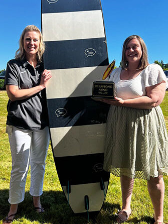 SSI coordinator, Kim Dwyer presenting Mid-Willamette Valley Community Action Agency resource coordinator Lisa Brunsin with the SIT Surfboard Award at the June end-of-year celebration. Submitted Photo