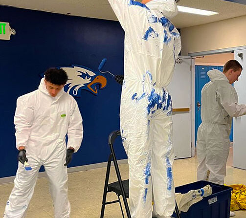 Stayton High School students Addison Samuell, Diego Salinas and Kale Hubert put a fresh coat of paint on the school’s hallways in February as part of the new Beautification Committee. Submitted Photo