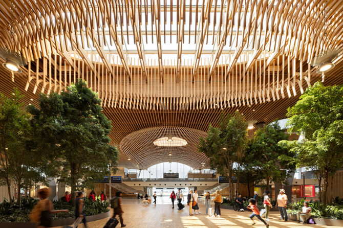 The mass plywood panels and other wood features at the upgraded Portland International Airport terminal can be easily seen in this interior view. Dozens of trees and thousands of plants were placed indoors to give the facility a forest feel. Courtesy Ema Peter