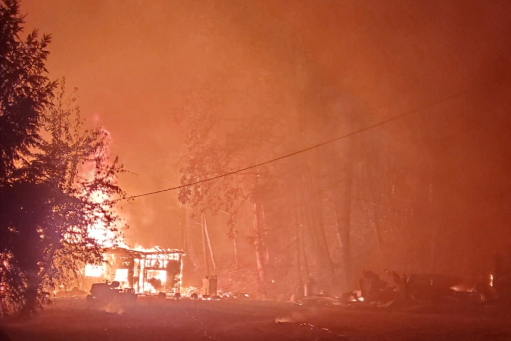 A picture of a burning building taken by Guy Edgerton as he and partner Dimond Edge evacuated the Santiam Fire in 2020. The couple had returned to their home in Mill City to retrieve medication left behind during their initial evacuation, and this image shows the intensity of the fire as they drove down Hwy. 22 back to Salem.